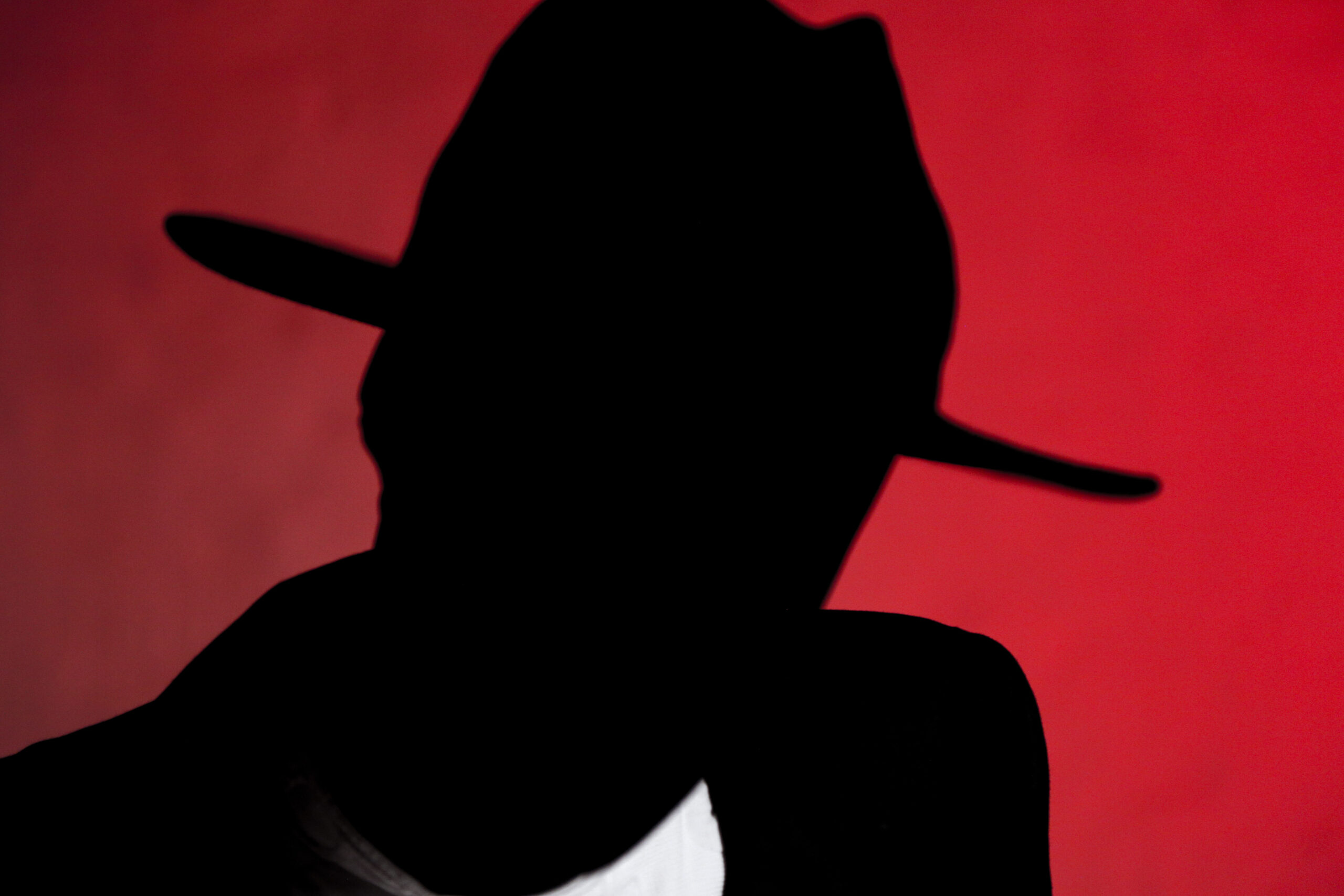 Dark shadow figure with wide brim hat
